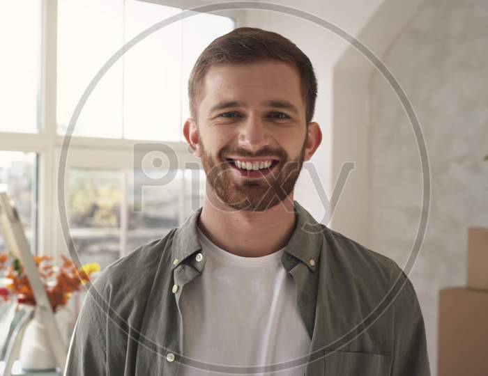 Portrait Of Young Man Putting On Medical Mask Smilling. Shot On Red