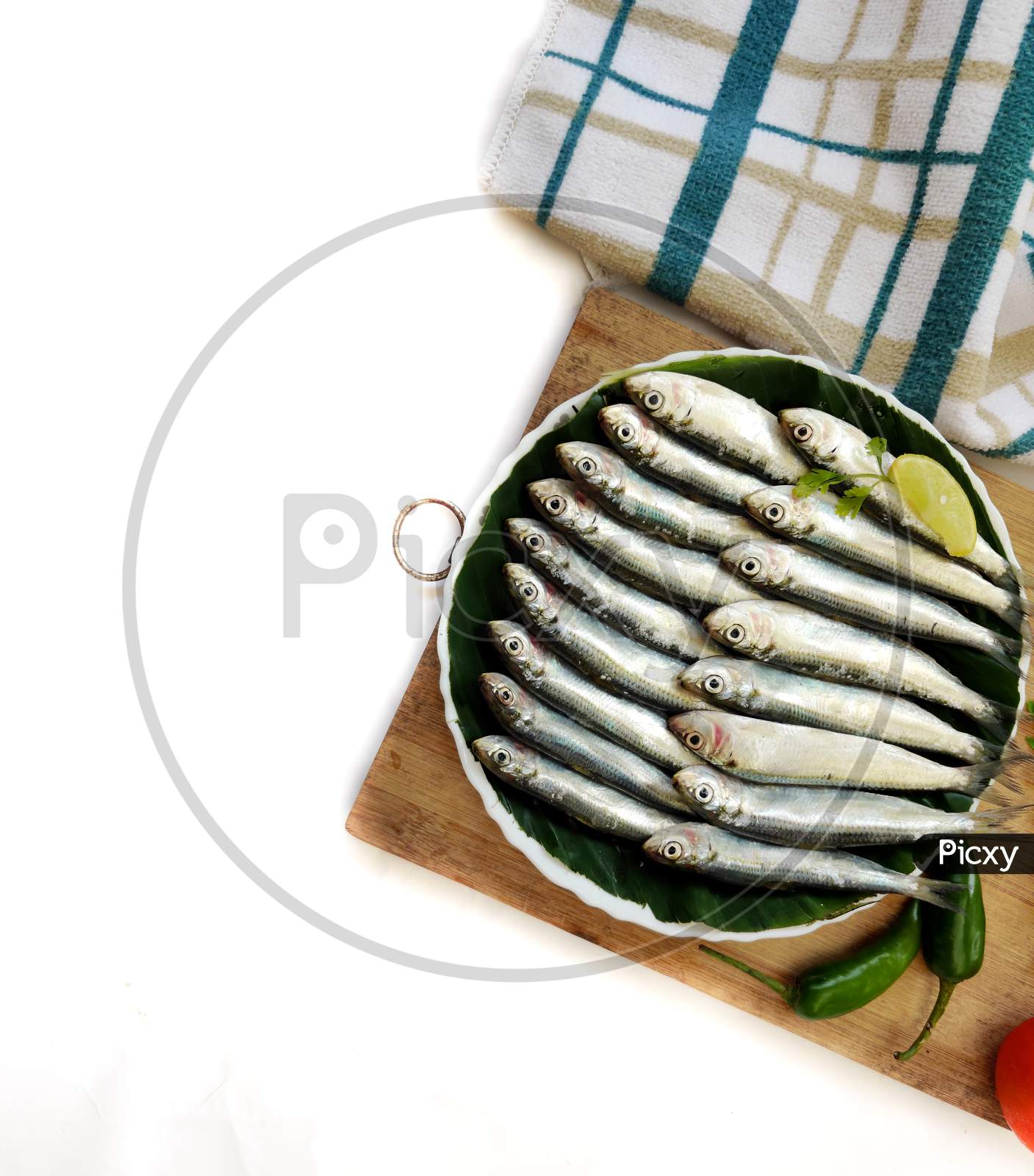 Closeup View Of Fresh Indian Oil Sardine Decorated With Herbs And Vegetables,Selective Focus.White Background.