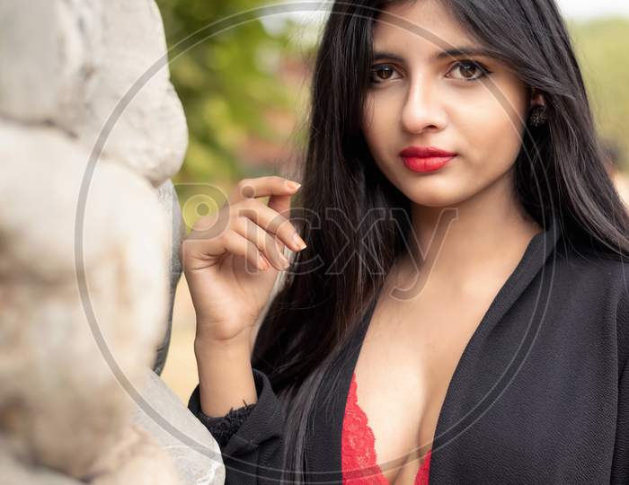 Portrait Of Very Beautiful Young Attractive Woman Wearing Red Outfit With Black Jacket Posing Fashionable In A Blurred Background. Lifestyle And Fashion.