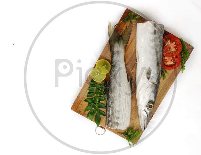 Fresh Raw Barracuda Fish (Cheelavu) Head And Body Decorated With Herbs And Vegetables On A White Background.Selective Focus.Space For Text.