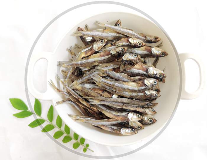 Dried Anchovy Fish Decorated With Herbs And Lemons On A White Background,Selective Focus.