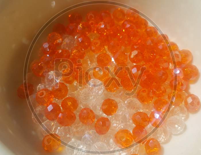 Shining, Transparent, Orange Color Crystal Beads Or Gemstones In A Bowl