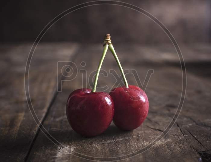 Freshly Picked Cherries On Dark Wooden Table