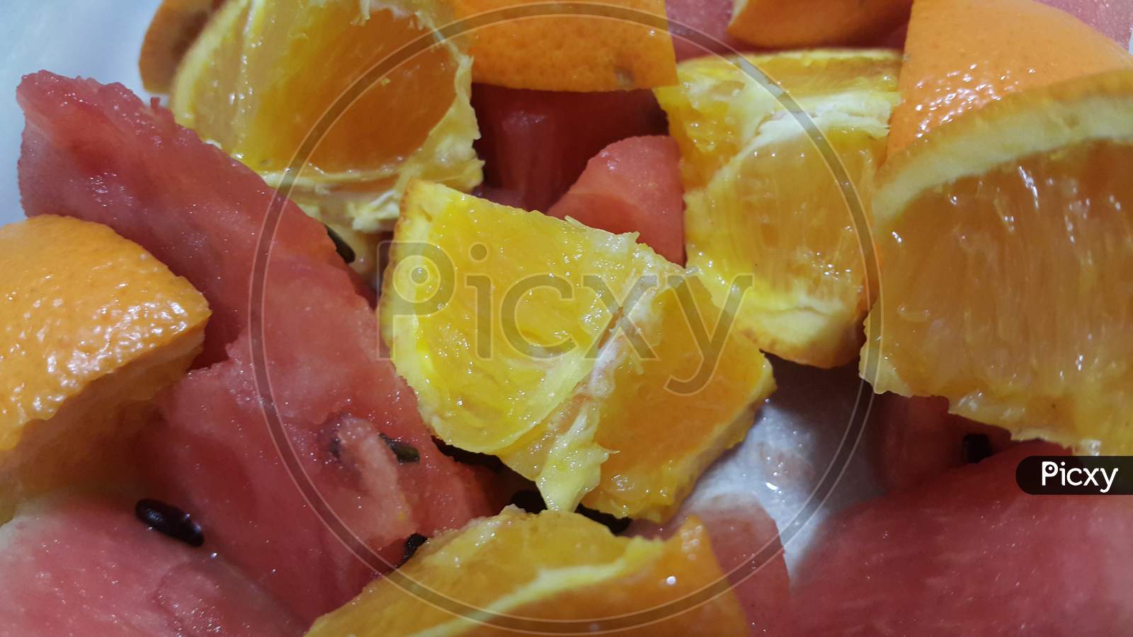 Closeup View Of Mixed Fruits Slices Of Citrus Oranges And Sweet Red Watermelon