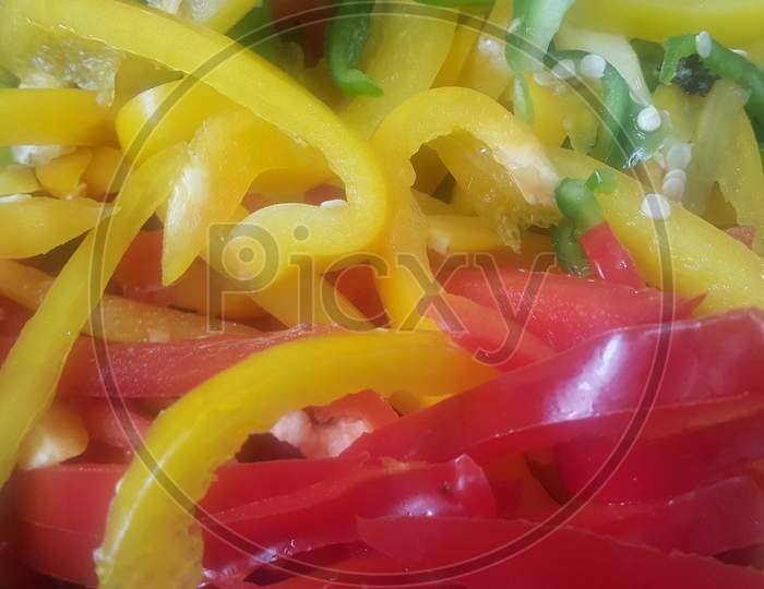 Slices Of Colorful Green, Yellow, Red, Purple Hot Shiny Shimla Chilli Or Peppers
