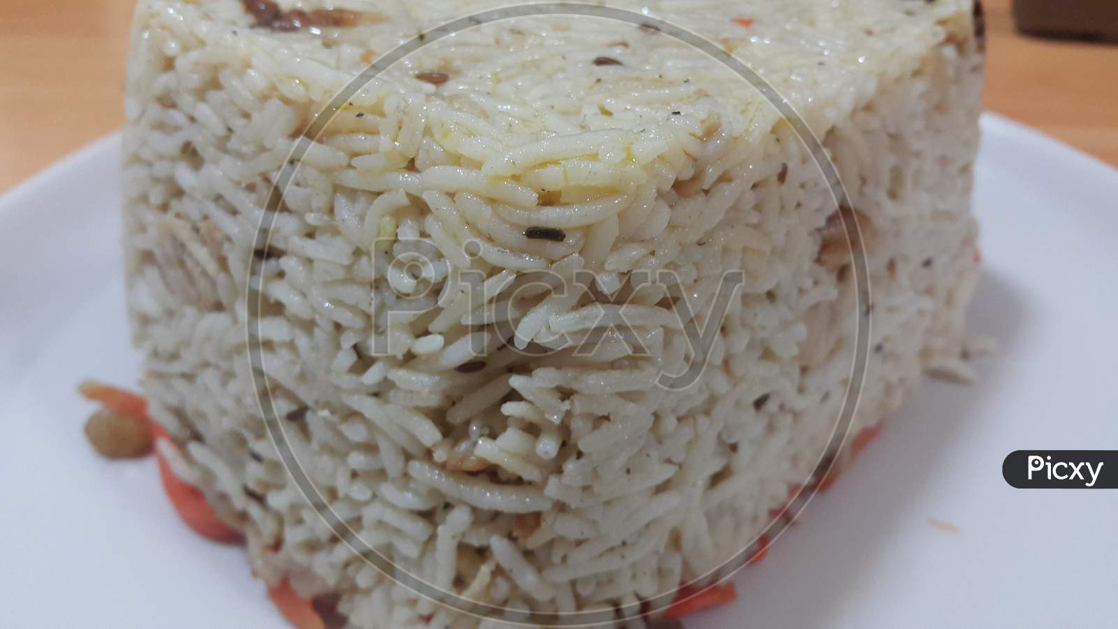 Closeup Of Frozen White Rice Cake In A White Plate Over Wooden Floor