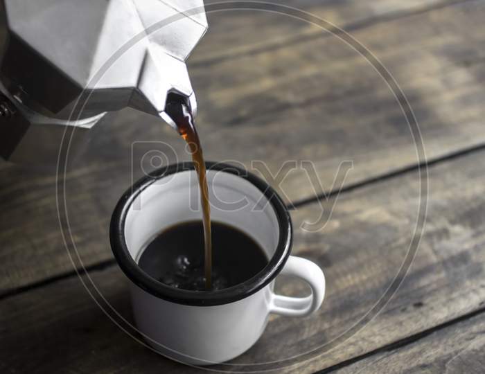 Pouring Black Coffee In The Cup