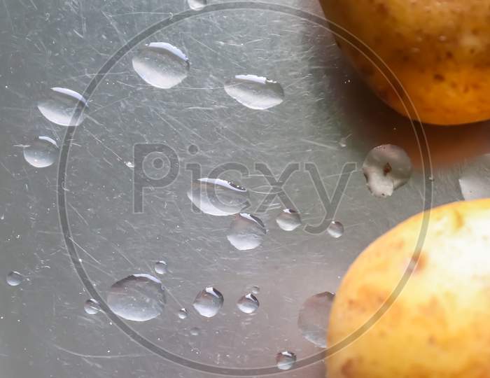 Top View At Uncooked Potatoes On A Metallic Surface. Kitchen Concept