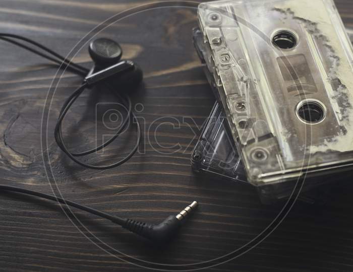 Top View  Shot Of Retro Tape Cassette With Earphone  On Wood Table.