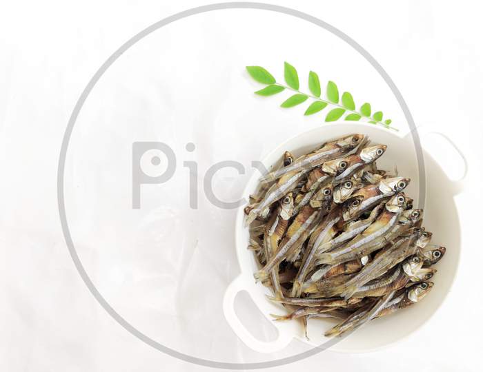 Dried Anchovy Fish Decorated With Herbs And Lemons On A White Background,Selective Focus.