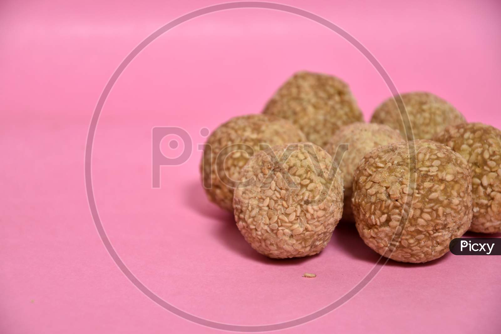 Indian sweet dish,Sesame seeds ball or called in hindi, til ke laddu on pink background.