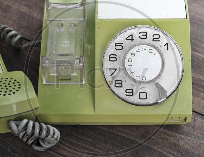 Green Old-Fashioned Telephone On Wooden Background