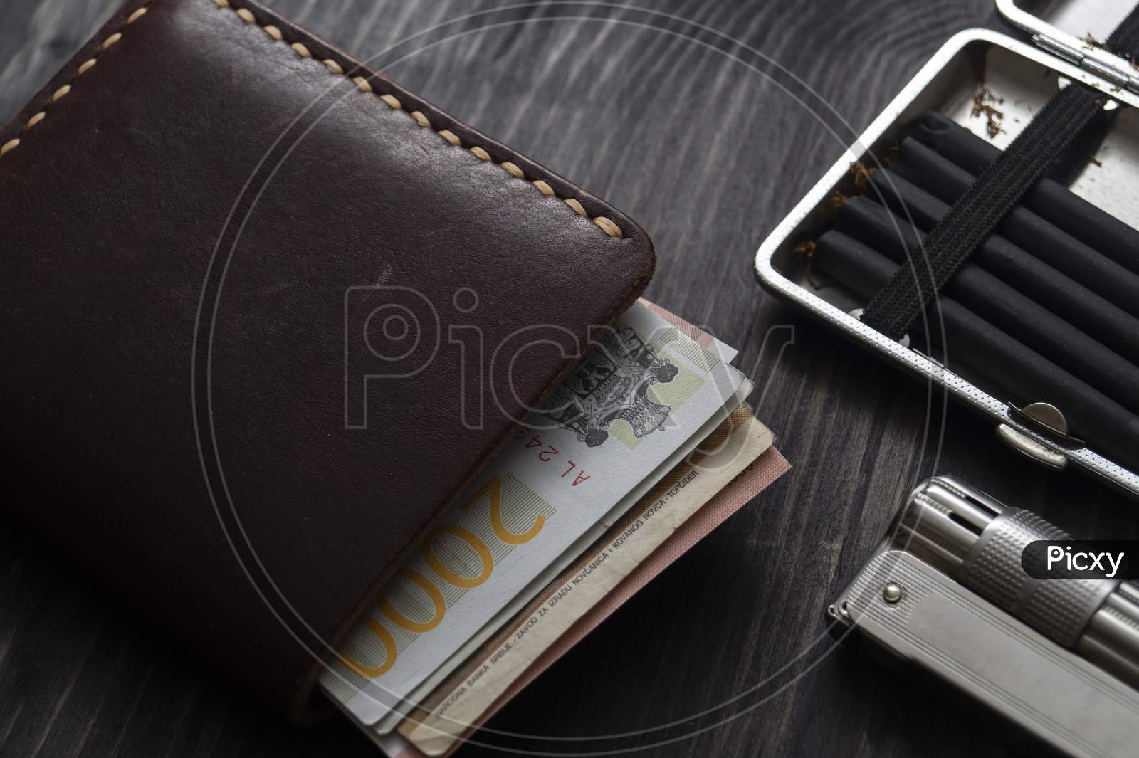 Cigarette Lighter And Leather Wallet On A Wooden Background