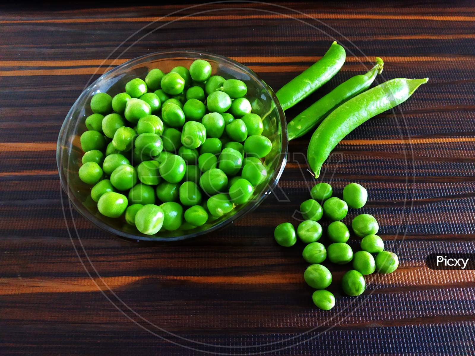 Fresh Green Peas with Pea Pods on an Isolated Brown background