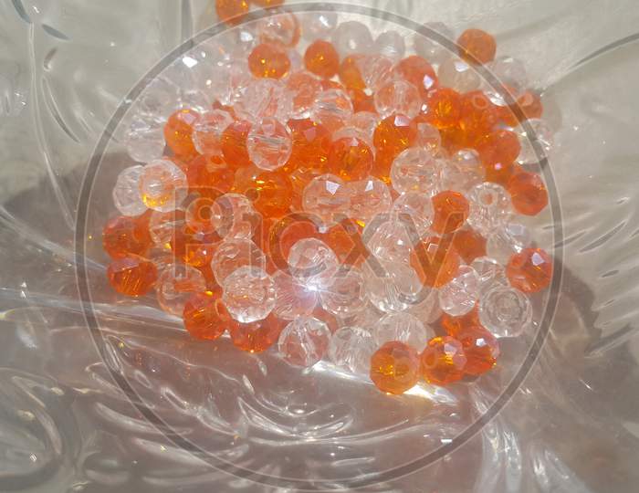Shining, Transparent, Orange Color Crystal Beads Or Gemstones In A Glass Bowl
