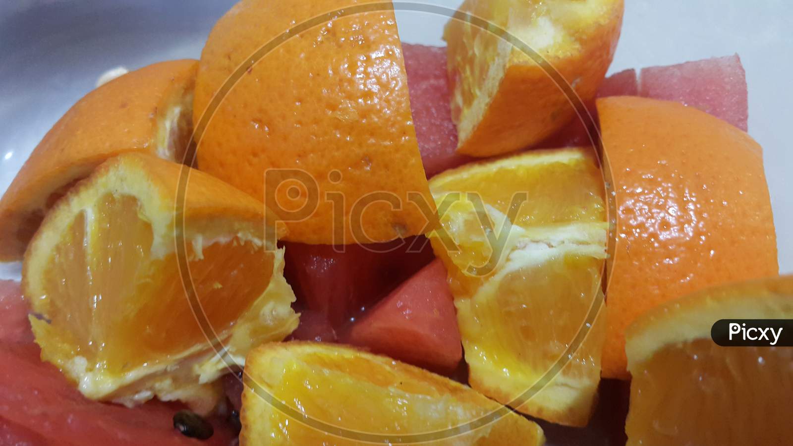 Closeup View Of Mixed Fruits Slices Of Citrus Oranges And Sweet Red Watermelon