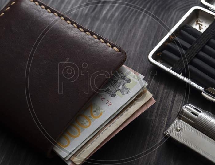 Cigarette Lighter And Leather Wallet On A Wooden Background