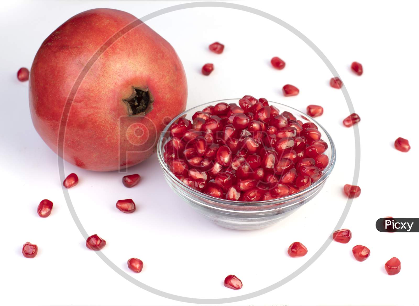 Bowl Of Pomegranate Seed Along With A Pomegranate Fruit