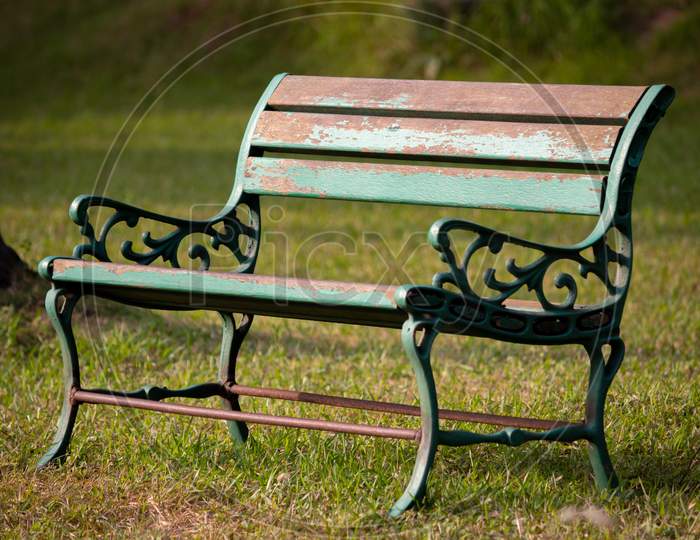 A Steel Bench In A Green Grass Field. Empty Chair In A Park. Focus Set Of Chair Grill