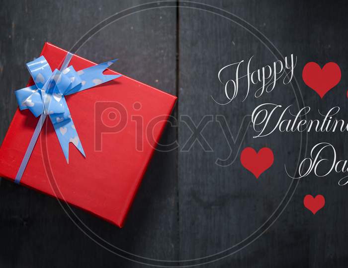 Red Hearts, Rose, Ribbon, Message Card And Gift Box On Wooden Table. Valentines Day Background