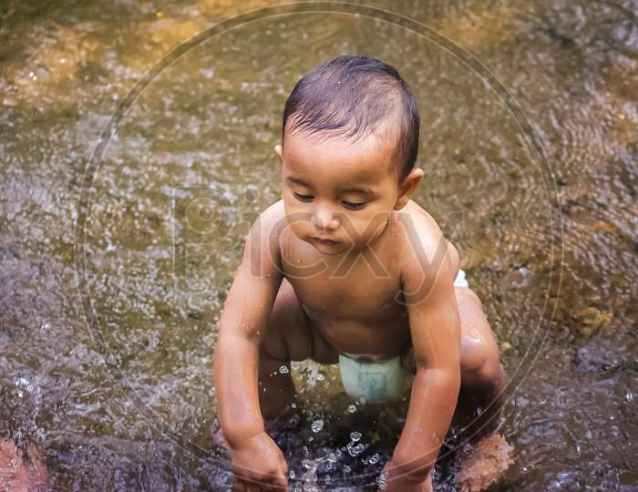 Baby Boy Stock Images - Little Cute Baby Boy Playing In River Water. Portrait of Boy Child Having Fun and Joy On a Forest River. Little Funny Boy Playing In Water.