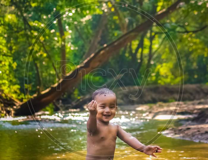 Baby Boy Stock Images -  Little Cute Baby Boy Playing In River Water. Portrait of Boy Child Having Fun and Joy On a Forest River. Little Funny Boy Playing In Water.