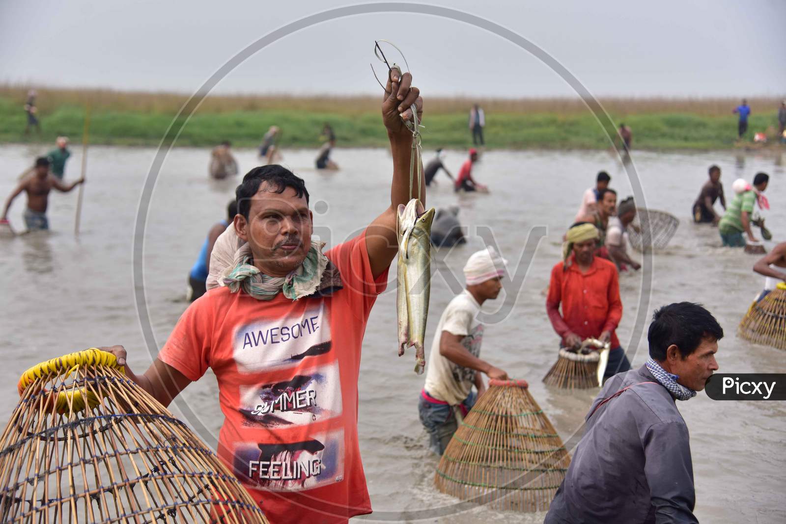 An Indian villager shows his catch as he participates in community fishing as part of Bhogali Bihu celebrations at Dighali Lake in Nagaon district, in the northeastern state of Assam on Jan 13,2021