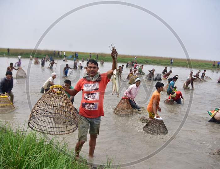 An Indian villager shows his catch as he participates in community fishing as part of Bhogali Bihu celebrations at Dighali Lake in Nagaon district, in the northeastern state of Assam on Jan 13,2021