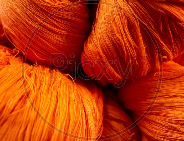 Close View Of The Orange Color Thread Yarns Used In Textile Industry
