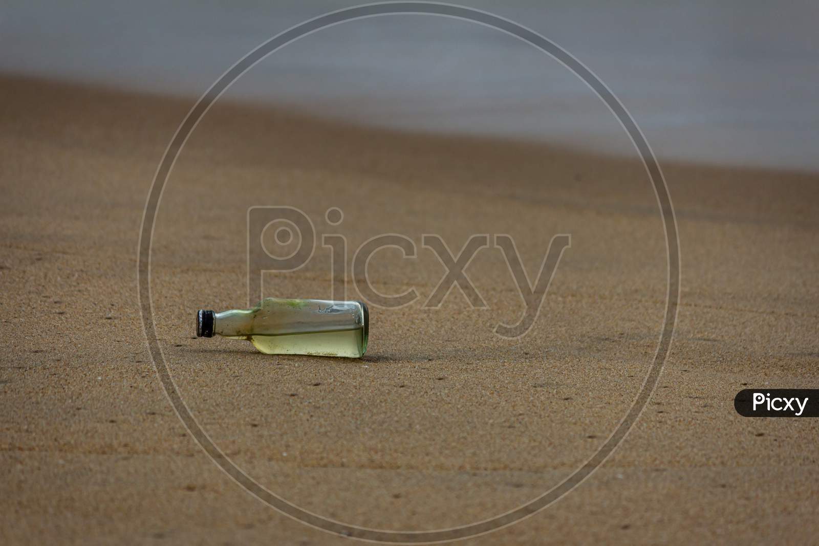 Glass Bottle In Sand, Marina Beach, Chennai, India. Debris In The Beach