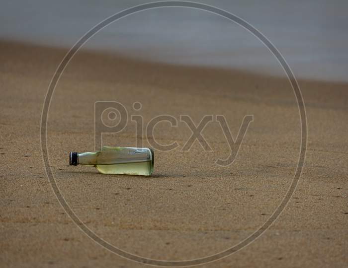 Glass Bottle In Sand, Marina Beach, Chennai, India. Debris In The Beach