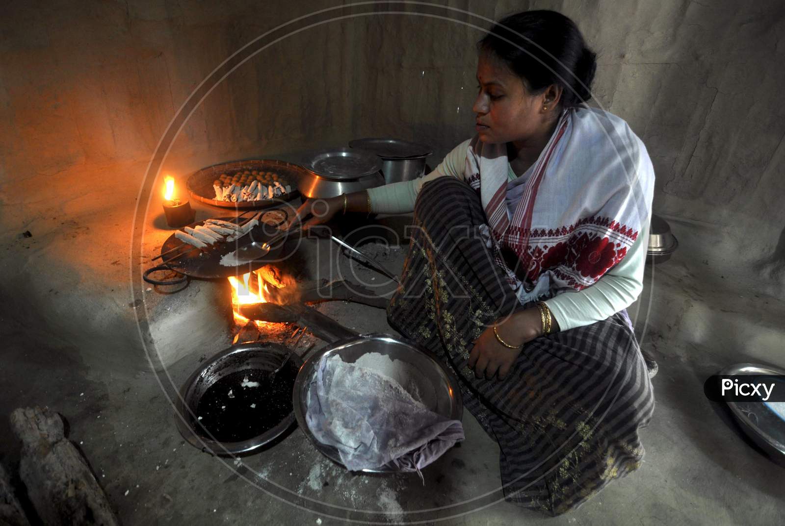 A Woman making  pitha on the eve of Bhogali Bihu Festival In Mayong Village In Morigaon District Of Assam, Jan. 11, 2021.
