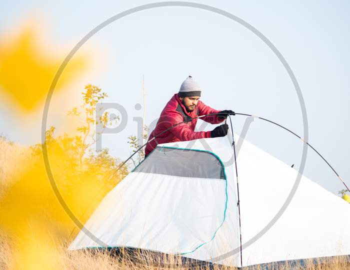 Traveler Busy Setting Up Camping Tent On Top Of Mountain - Tourism, Travel, Hiking And Trekking Concept.