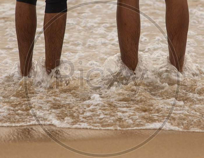 Friends Enjoying The Waves In The Beach, Marina Beach, Chennai. Focus Set On Legs