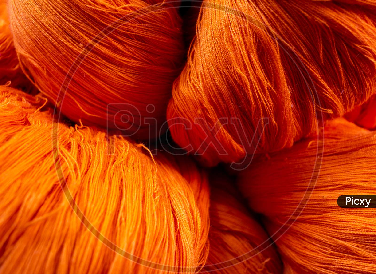 Close View Of The Orange Color Thread Yarns Used In Textile Industry