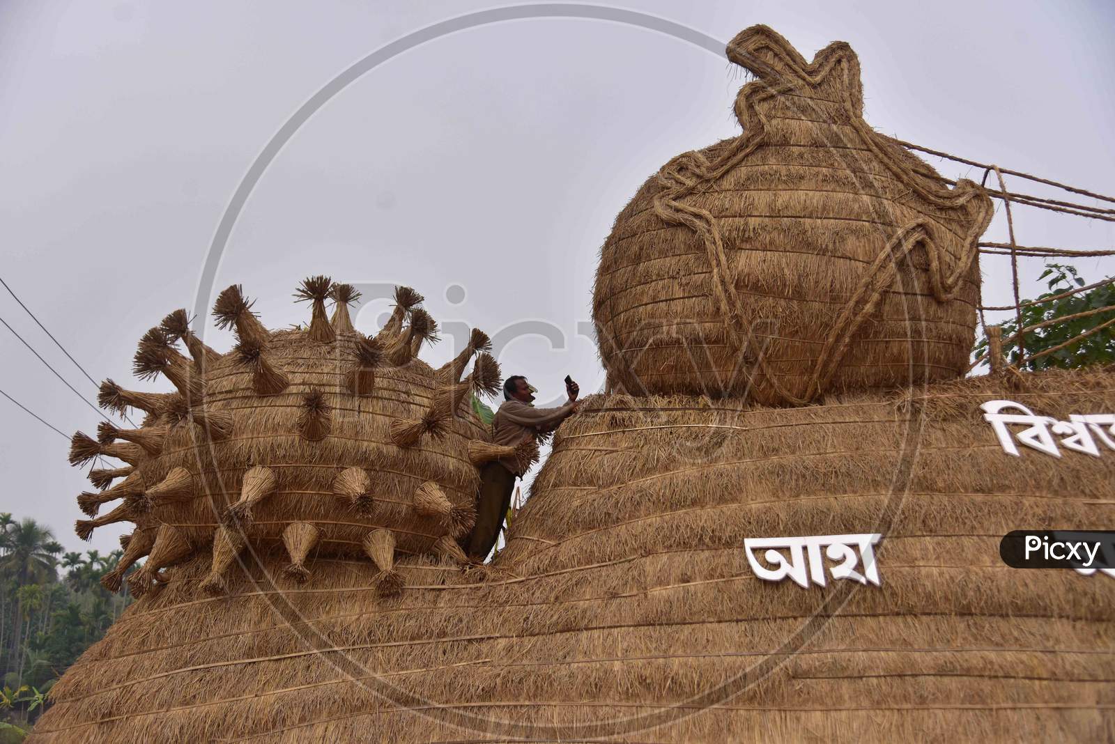Workers prepare a makeshift cottage called Bhelaghar with protecting the world from COVID-19 as a theme ahead of the Magh Bihu festival in Nagaon district, in the northeastern state of Assam on Jan 13,2021