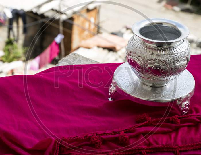 Beautiful Carved Silver Pot Or Kalash And Stand Used In Hindu Rituals, On Blur Background.