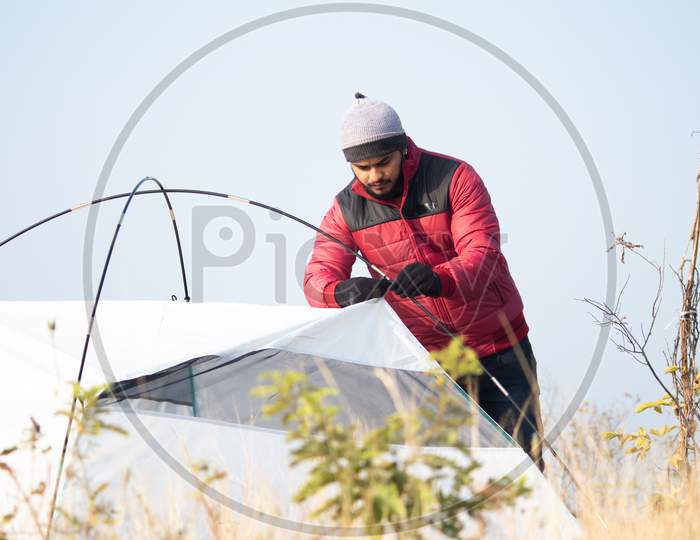Hiker Busy Setting Up Camping Tent On Top Of Hill - Tourism, Travel, Hiking,Camping And Trekking Concept.