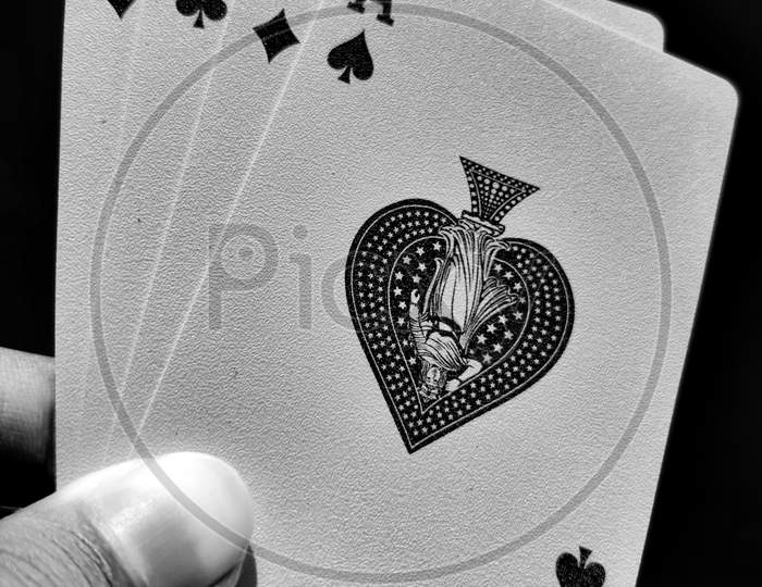 Black And White Playing Cards All Aces Aligned In The Corner, Holding In Hand Or Fingers Against The Sky