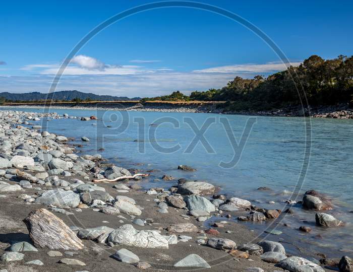 Countless Rocks Strewn Along The Okarito River In New Zealand