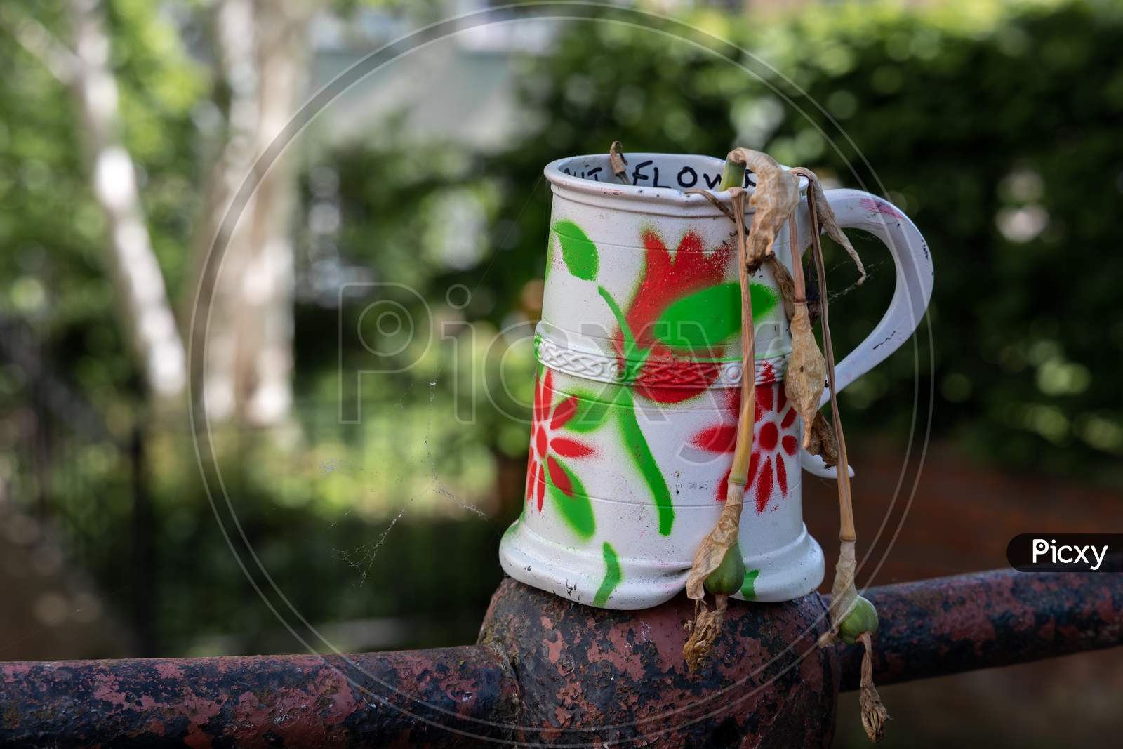 Old Dented And Painted Tankard Containing Dead Daffodils