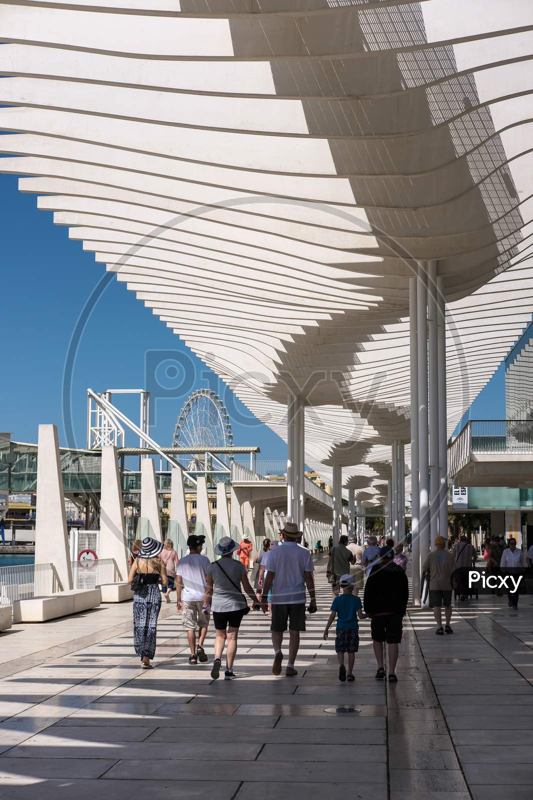 People Walking Under The Modern Pergola In The Harbour Area Of Malaga