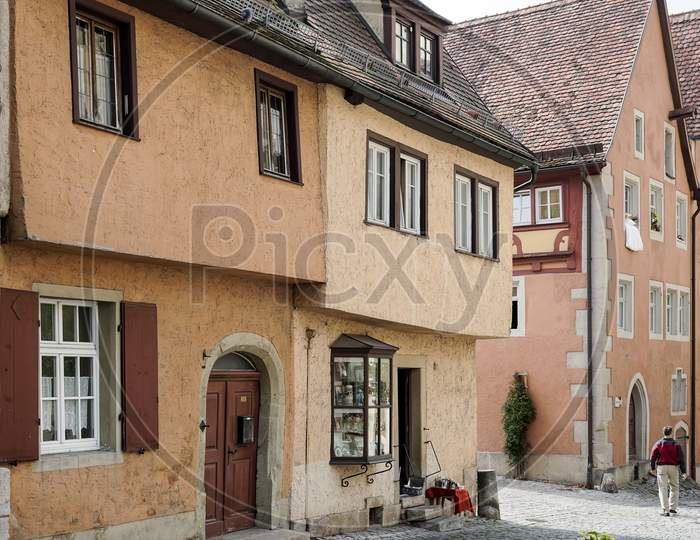 Man Walking Along A Picturesque Street In Rothenburg