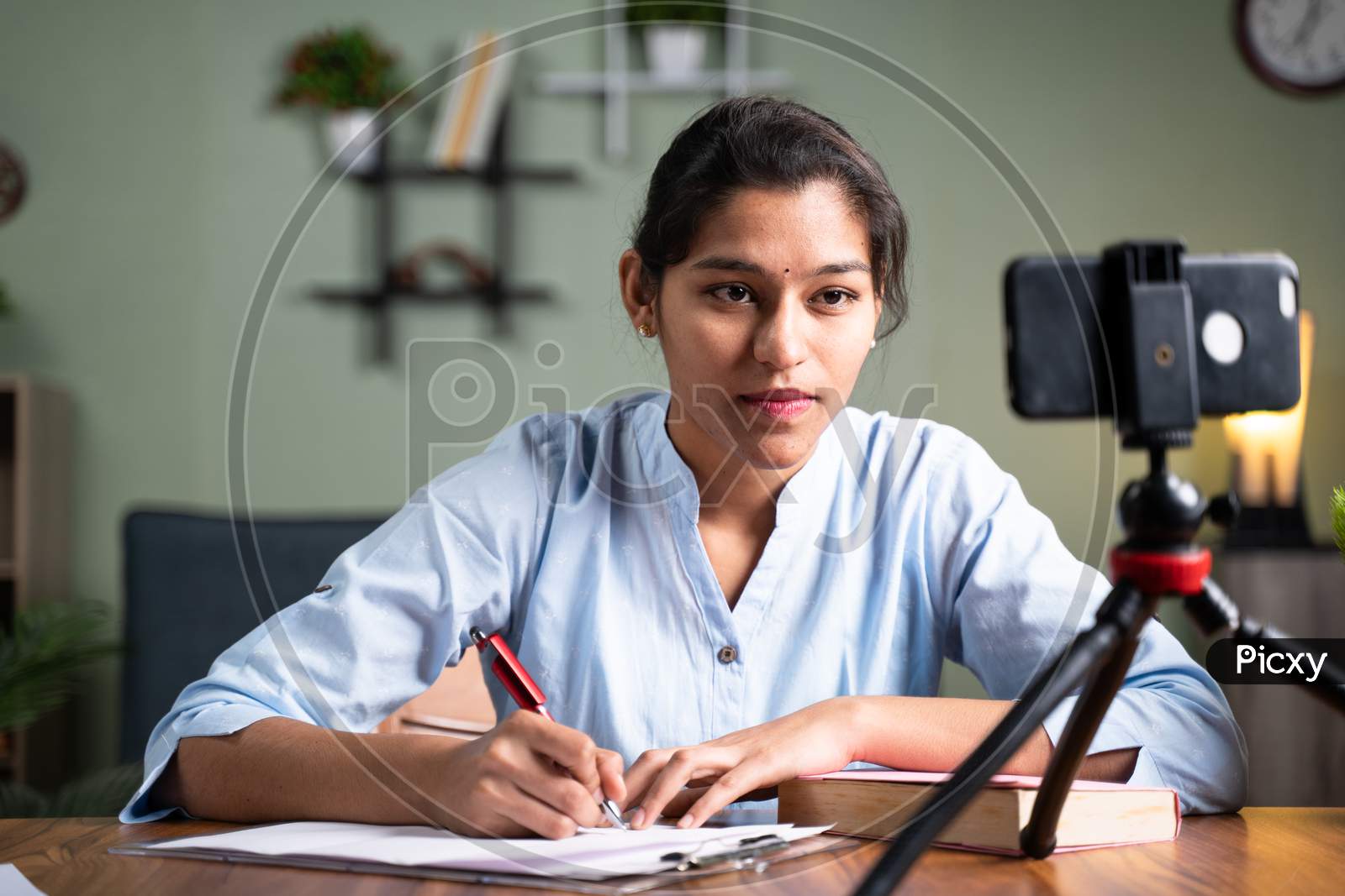 Young College Girl Student Writing Notes By Looking Into Mobile Phone During Online Class - Concept Of New Normal, Virtual Learning, Online Education During Coronavirus Or Covid-19 Pandemic.