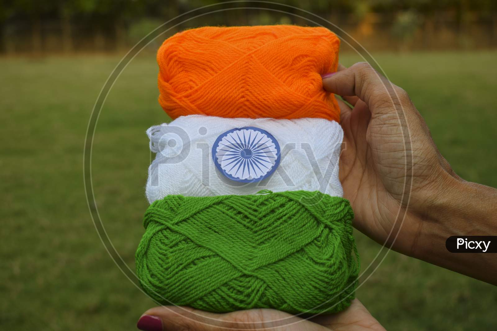 Indian Flag Tricolor Tiranga Saffron, White And Green Embroidery Threads. Female Palms Holding Embroidered Thread As Concept For Indian Republic Day Celebration Depicting Concept Of Freedom