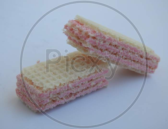 Broken pieces of multiple layered strawberry fruit flavor cream filled wafers isolated on white background