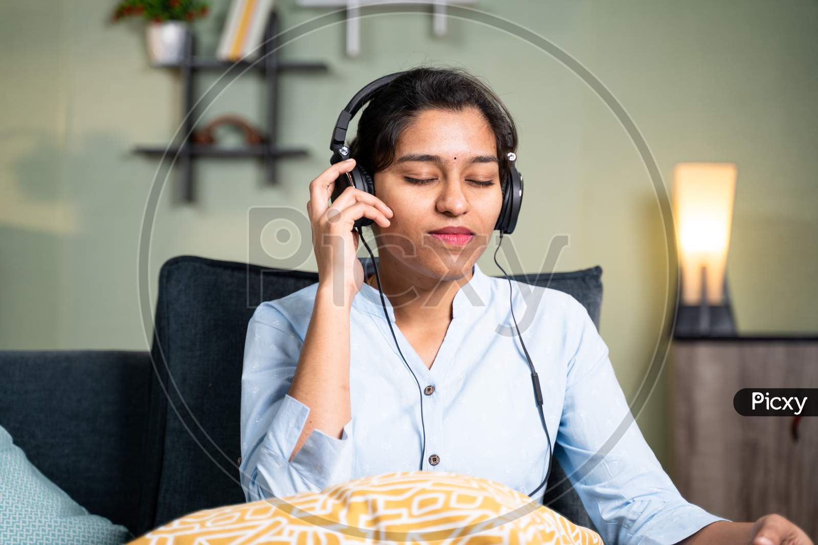 Young Girl Listening Peaceful Music At Home While Lying On Sofa After Coming From Office - Concept Of Music Lover, Lazy Weekend Relaxation And Modern Day Lifestyle