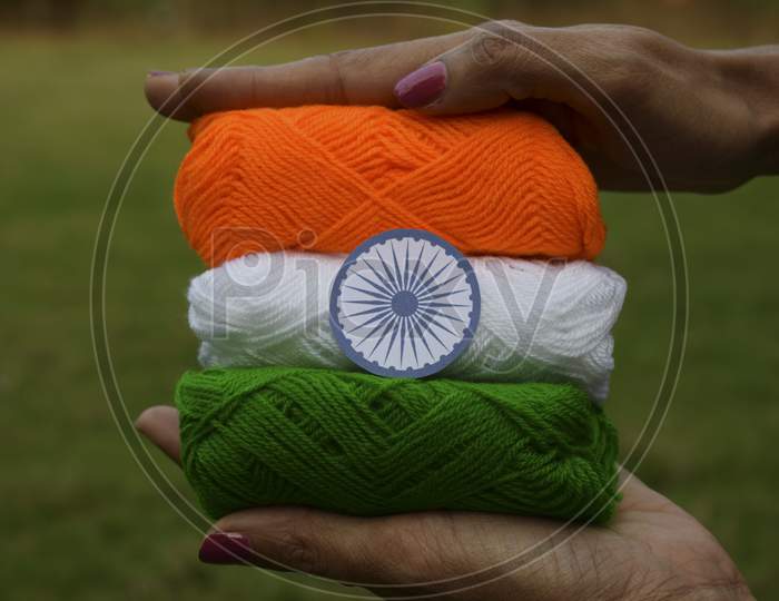 Indian Flag Tricolor Tiranga Saffron, White And Green Embroidery Threads. Female Palms Holding Embroidered Thread As Concept For Indian Republic Day Celebration Depicting Concept Of Freedom
