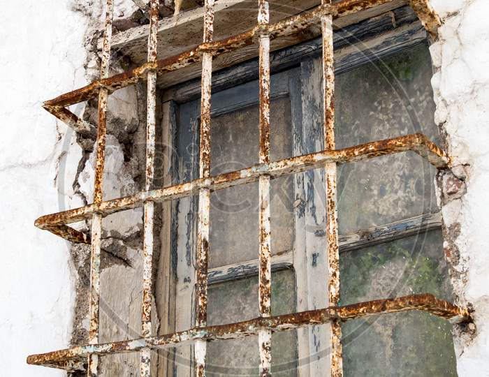Rusting Bars Across A Window Of A Derelict Building In Casares Spain