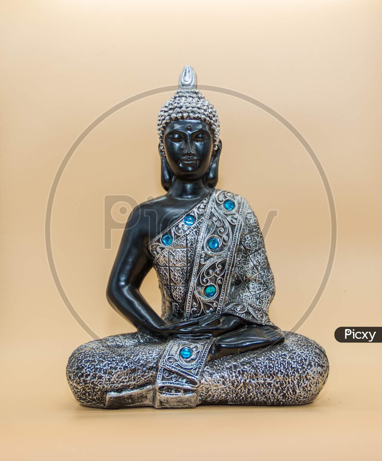 A Small Image Of Buddha In Lotus Position Isolated On Light Background